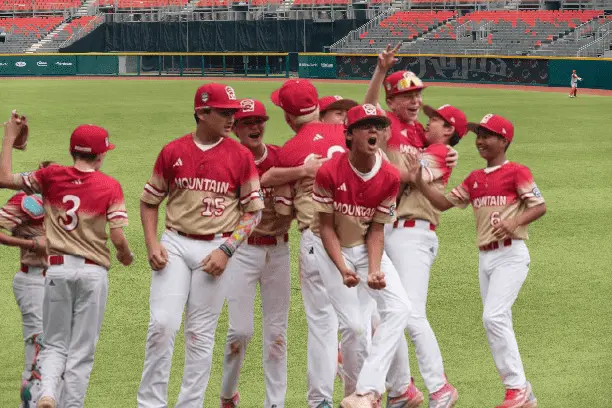 Summerlin South Wins U.S. Title, Advances to LLWS Final 2 La Laquer players celebrating U.S. title win in LLWS with scoreboard showing 8-2.
